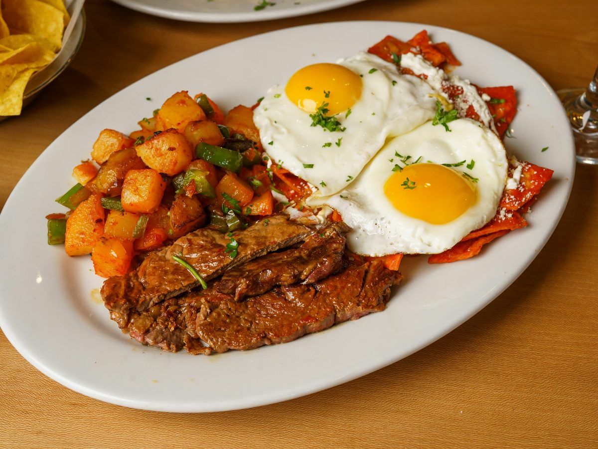 Steak with two fried eggs and roasted potatoes — illustrative